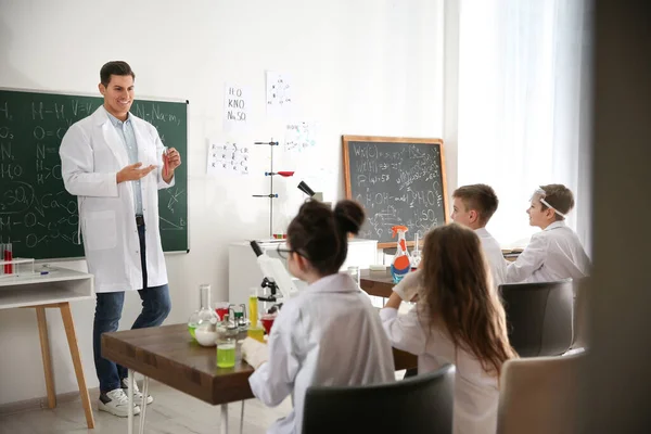 Učitel s žáky ve třídě chemie — Stock fotografie