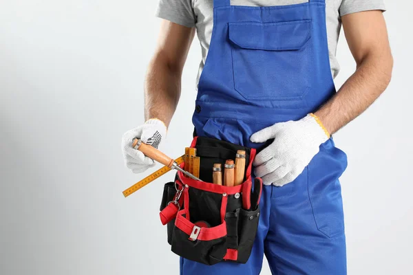 Charpentier avec ceinture à outils sur fond clair, gros plan — Photo