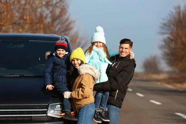 Gelukkig gezin met kleine kinderen in de buurt van moderne auto op de weg — Stockfoto