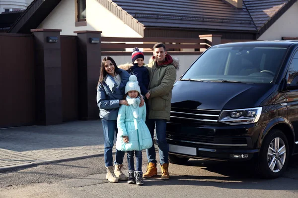 Glückliche Familie mit kleinen Kindern in der Nähe moderner Autos auf der Straße — Stockfoto