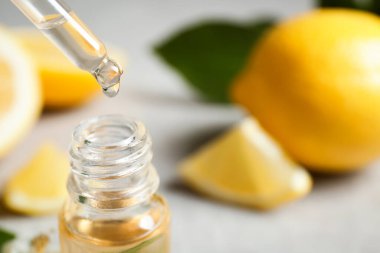 Citrus yağı pipetten şişeye damlıyor, yakın plan. Metin için boşluk