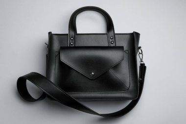 Açık gri arka planda şık bir kadının çantası, üst manzara.