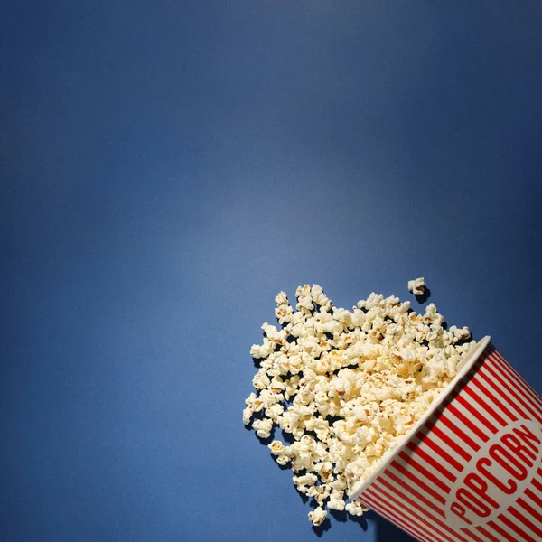 Deliciosas palomitas de maíz sobre fondo azul, vista superior. Espacio para texto —  Fotos de Stock