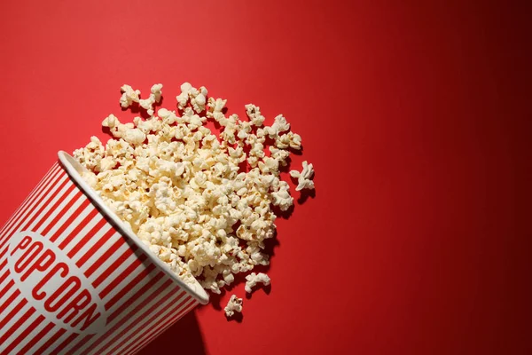 Köstliches Popcorn auf rotem Hintergrund, Draufsicht. Raum für Text — Stockfoto