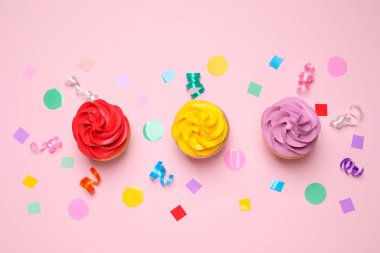 Açık pembe arka planda renkli doğum günü kekleri, düz uzanma