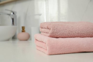 Banyo tezgahında bir yığın temiz havlu var.