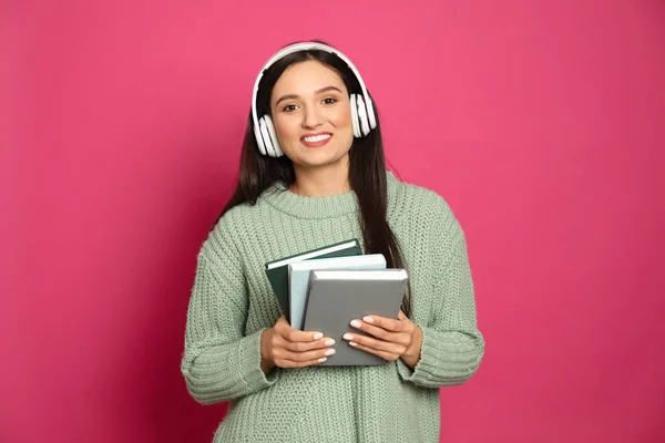 Junge Frau Hört Hörbuch Auf Rosa Hintergrund — Stockfoto