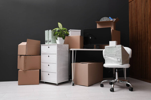 Картонные коробки и упакованные вещи в офисе. День переезда
