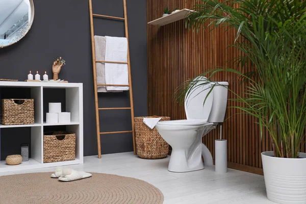 Elegant modernt badrum med toalett skål nära trävägg — Stockfoto