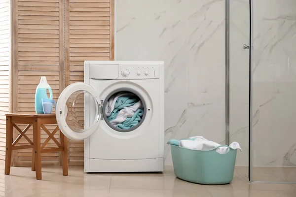 Máquina de lavar roupa moderna com toalhas no banheiro — Fotografia de Stock