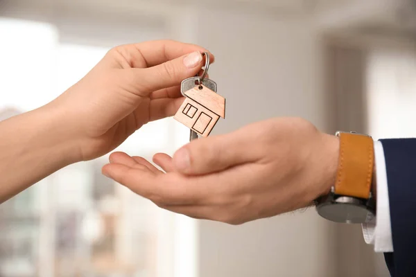 Агент з нерухомості дає ключ з дрібничкою для клієнта в офісі, c — стокове фото