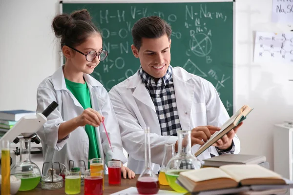 Profesor con alumno haciendo experimento en la mesa en clase de química —  Fotos de Stock