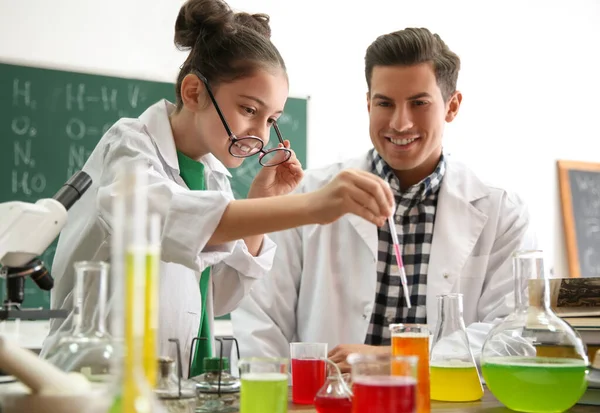 Lärare med elev gör experiment vid bordet i kemi klass — Stockfoto