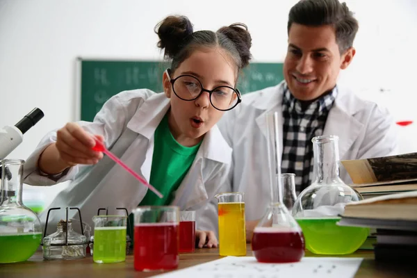 Professor com aluno fazendo experiência na mesa em aula de química — Fotografia de Stock