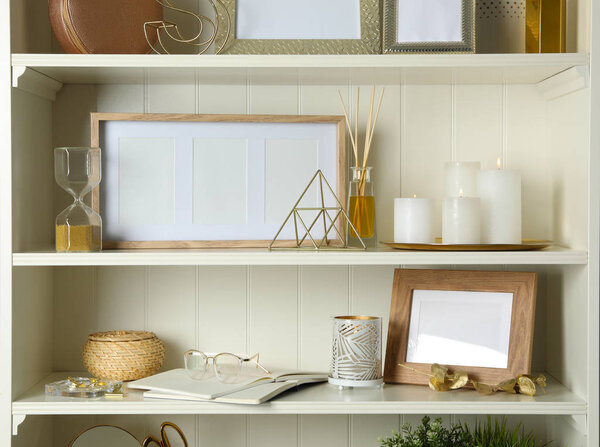 White shelving unit with photo frames and different decorative elements