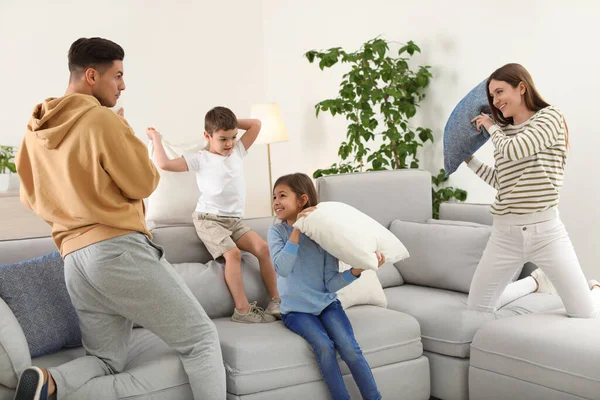 거실에서 베개 싸움을 하고 있는 행복 한 가족 — 스톡 사진