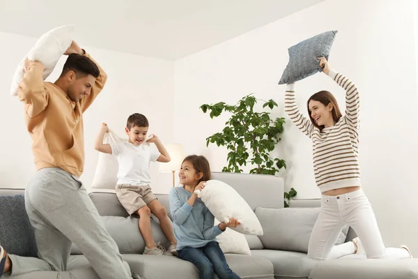 Szczęśliwa rodzina mając walki na poduszki w salonie — Zdjęcie stockowe