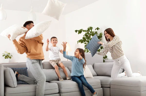 Happy family having pillow fight in living room — Stock Photo, Image