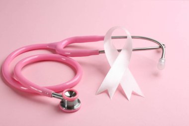 Renkli arka planda pembe kurdele ve steteskop, yakın plan. Göğüs.