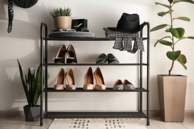Black shelving unit with shoes and different accessories near wh clipart