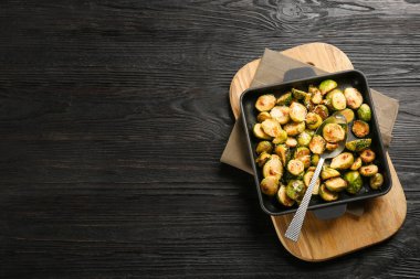 Delicious roasted brussels sprouts with grated cheese on black w clipart