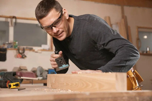 Profesjonalne stolarz szlifowanie deski drewnianej z płaszczyzną jack w — Zdjęcie stockowe