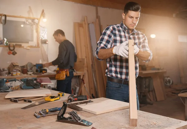 Professionele timmerman en collega werken met houten plank i — Stockfoto