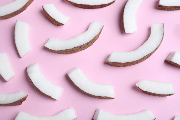 Fresh coconut pieces on pink background, above view