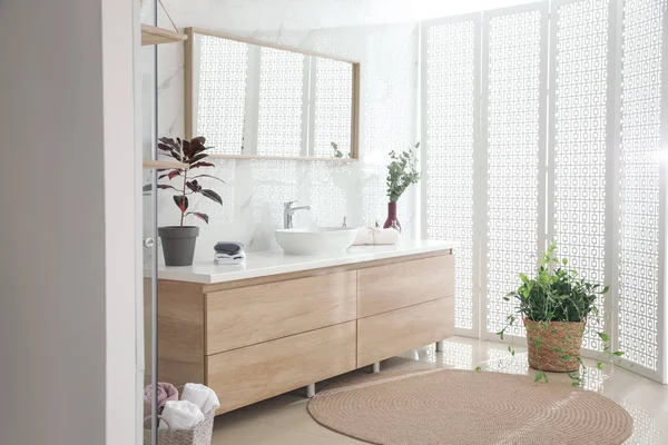 Élégant intérieur de salle de bain avec comptoir, miroir et plantes. De — Photo