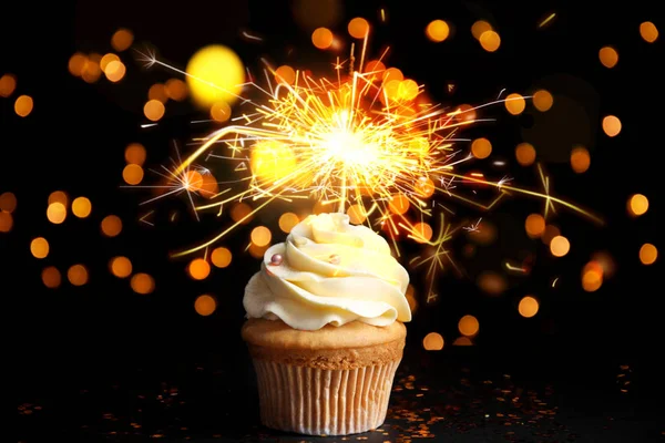 Beautiful birthday cupcake with sparkler on black table against — 스톡 사진