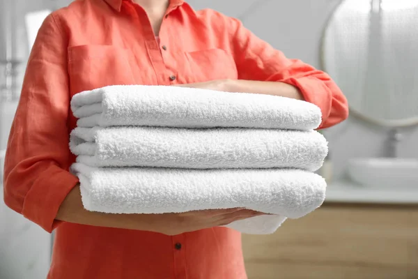 Woman holding fresh towels in bathroom, closeup — Stock Photo, Image