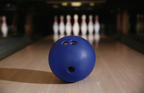 Blue ball on bowling lane in club