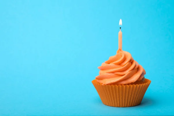 Lahodný narozeninový dortík s pomerančovou smetanou a hořící svíčkou — Stock fotografie