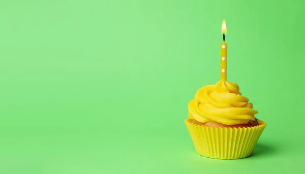 Lahodný narozeninový dortík se žlutou smetanou a hořící svíčkou — Stock fotografie
