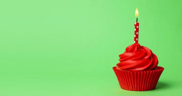 Délicieux cupcake d'anniversaire avec crème rouge et bougie allumée — Photo