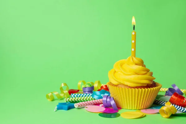 Delicioso cupcake de cumpleaños con crema amarilla y vela encendida —  Fotos de Stock