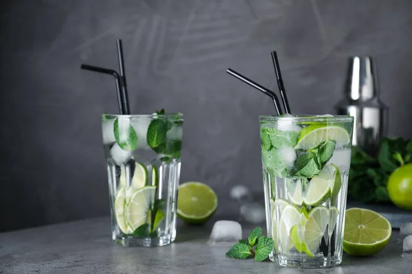 Bicchieri di cocktail Mojito fresco sul tavolo grigio — Foto Stock