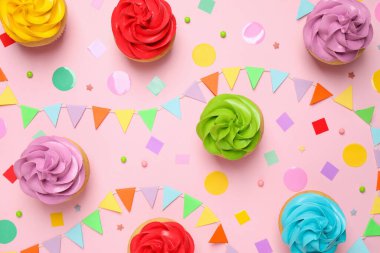 Açık pembe arka planda renkli doğum günü kekleri, düz uzanma