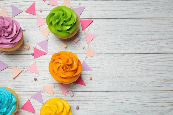 Cupcakes coloridos de aniversário na mesa de madeira branca, flat lay. Espada. — Fotografia de Stock