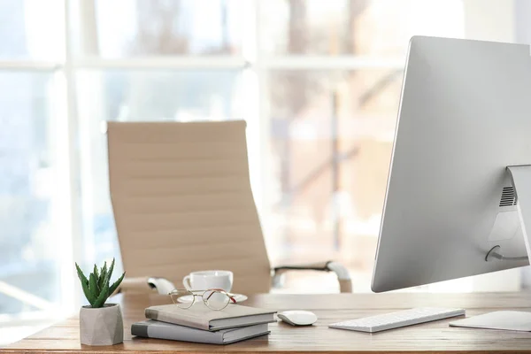 Computer, notebooks and coffee on table in office