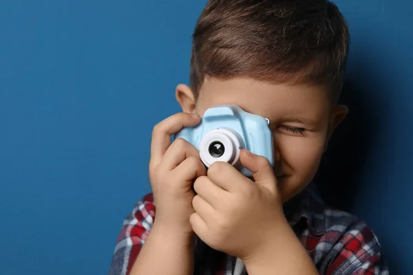 Piccolo fotografo scattare foto con macchina fotografica giocattolo su dorso blu — Foto Stock