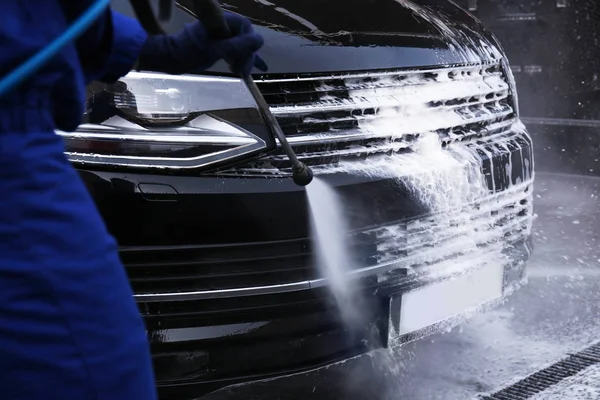 Worker cleaning automobile with high pressure water jet at car w — 스톡 사진