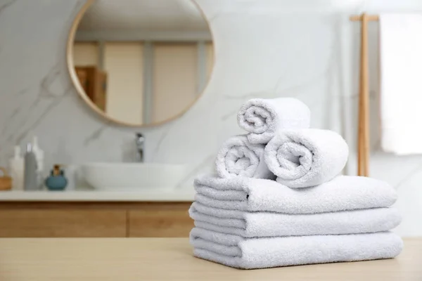 Vita handdukar på träbord i badrummet. Plats för text — Stockfoto