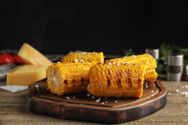 Ahşap masada nefis ızgara mısır koçanları.