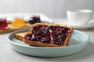 Delicious crispy toasts with jam on table
