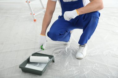 Man with roller and tray in room, closeup