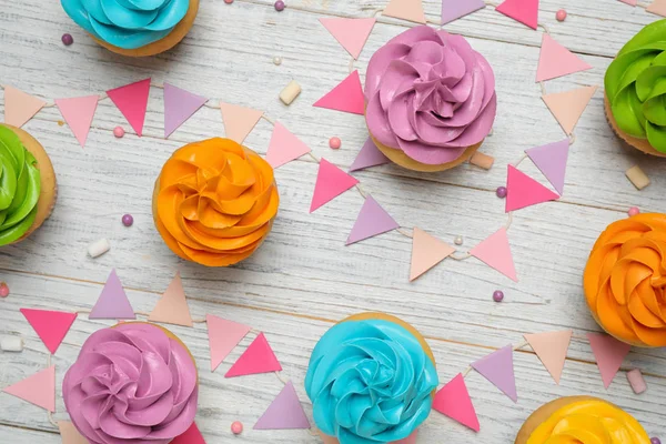 Coloridos cupcakes de cumpleaños en la mesa de madera blanca, la puesta plana — Foto de Stock