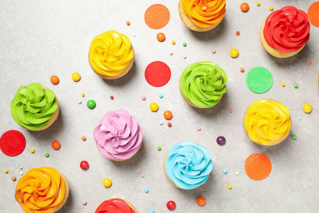 Colorful birthday cupcakes on light grey table, flat lay