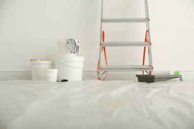 Stepladder and different tools near wall in room. Interior renov