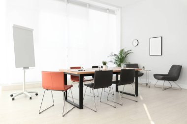 Büyük masası ve sandalyeleri olan basit bir ofis.